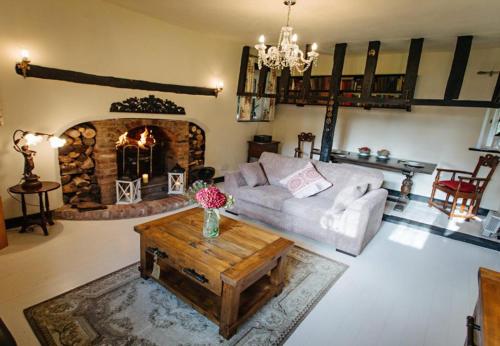 a living room with a couch and a fireplace at Breathtaking Elizabethan Manor House in Burnham on Crouch