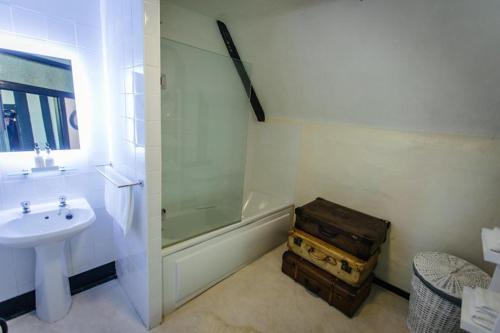 a bathroom with a tub shower and a sink at Breathtaking Elizabethan Manor House in Burnham on Crouch