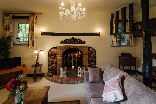 a living room with a fireplace and a chandelier at Breathtaking Elizabethan Manor House in Burnham on Crouch