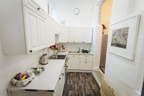 a white kitchen with white cabinets and a sink at Breathtaking Elizabethan Manor House in Burnham on Crouch