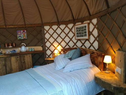 Tempat tidur dalam kamar di Cosy and Inviting Waterside Luxury Yurt