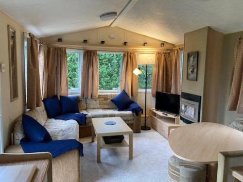 a living room with a couch and a table at Cosy Quiet Static Caravan Mawgan Porth St Eval in Wadebridge