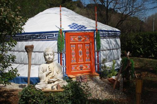 a statue of a buddha in front of a yurt at Bastide du Bonheur Saint Donat in Gréoux-les-Bains
