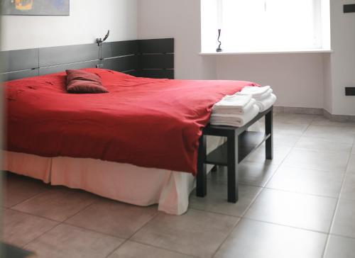 a bedroom with a red bed and a table with towels at Auri's House in Turin