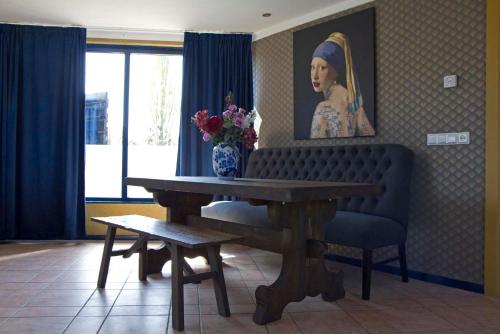 a living room with a bench and a portrait of a woman at Oud-Hollands Huus - Vakantiehuisje Veluwe in Ede