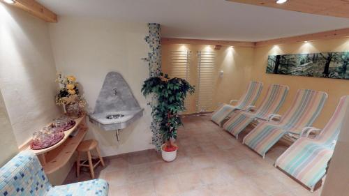 a bathroom with three chairs and a sink and a sink at Das kleine Familienhotel Koch in Eisentratten
