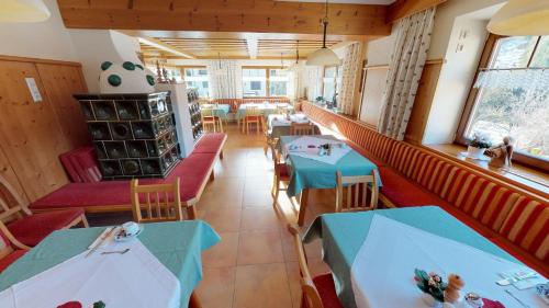 a restaurant with two tables and chairs in a room at Das kleine Familienhotel Koch in Eisentratten