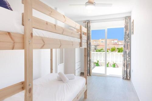 a bedroom with two bunk beds and a window at Bungalow Blue Dream 4 - Sea views, terrace and pool in Gran Alacant