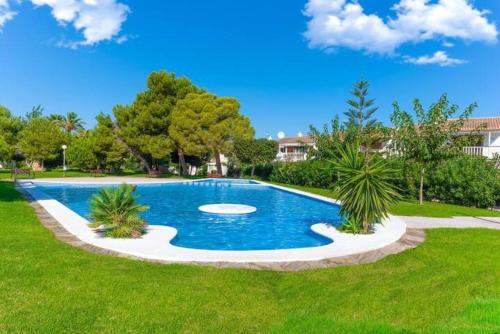 a swimming pool in the middle of a grass field at Bungalow Blue Dream 4 - Sea views, terrace and pool in Gran Alacant