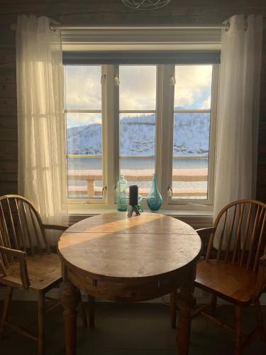 a table and chairs in front of a window at Sakrisøy Rorbuer in Reine