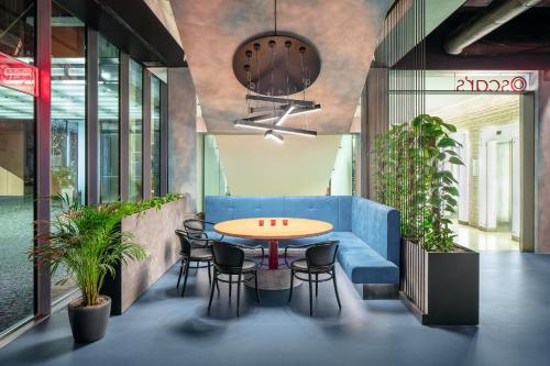 an office with a blue couch and a table and chairs at Vienna House by Wyndham Andel's Prague in Prague
