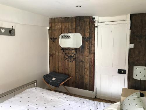 a bedroom with a bed and a wooden wall at The Anchorage your home in idyllic Staithes in Staithes