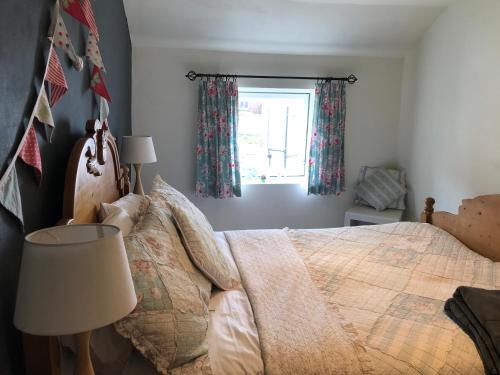 a bedroom with a bed and a window at The Anchorage your home in idyllic Staithes in Staithes