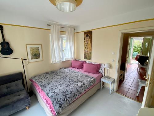 ein Schlafzimmer mit einem rosa Bett und einem Fenster in der Unterkunft Villa Musica in Aschau im Chiemgau