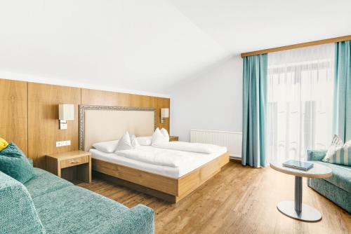 Habitación de hotel con cama y sofá en Hotel Weingut Rosenhof en Illmitz