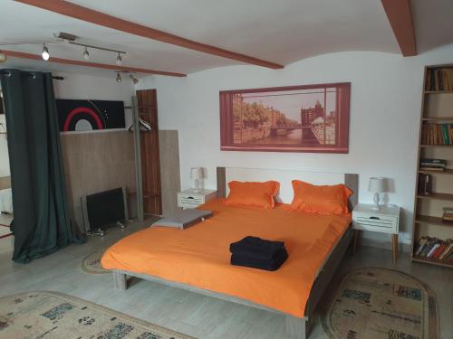 1 dormitorio con 1 cama grande con manta naranja en Atia Residence, en Sibiu