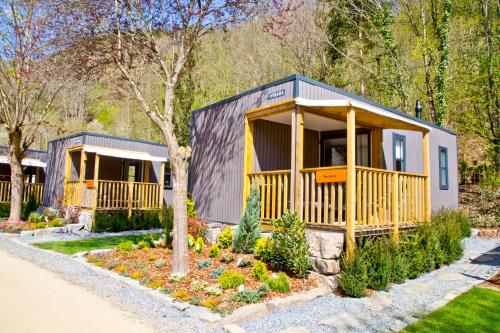 a tiny house with a large porch in a garden at Chalet Fuusslee in Goebelsmuhle