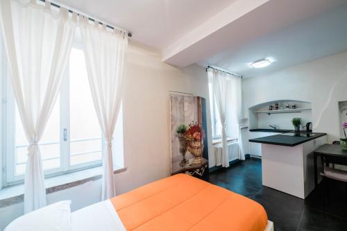 uma cama laranja num quarto branco com janelas em FEEL - Cozy Old Town em Bérgamo