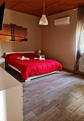 Schlafzimmer mit einem roten Bett und Holzboden in der Unterkunft Antica Compsa in Conza di Campania