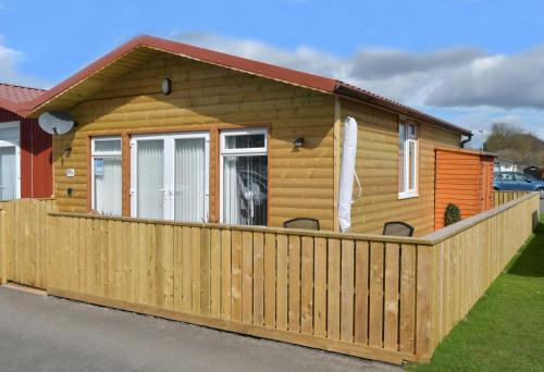 a log cabin with a wooden fence at Pet friendly sleeps 6 Chalet Bridlington free elec in Bridlington