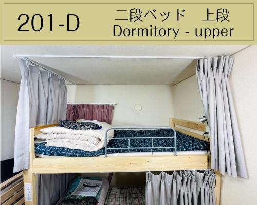a bedroom with a bunk bed in a room at Guesthouse Sakamichi Sampo in Kushiro