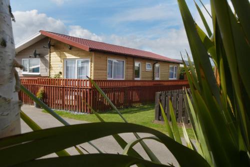a house with a red fence in front of it at Pet friendly sleeps 3 Chalet Bridlington free elec in Bridlington