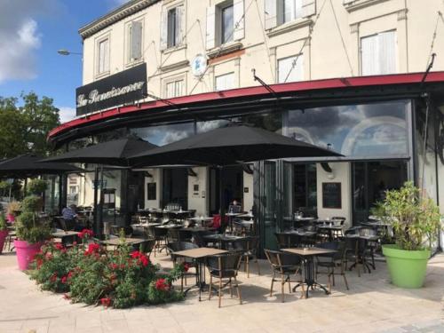 a restaurant with tables and umbrellas in front of a building at T2 hypercentre Libourne 5 min St Emillon in Libourne