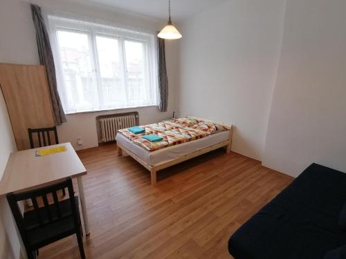 a bedroom with a bed and a table and a window at Bonvolon in Prague