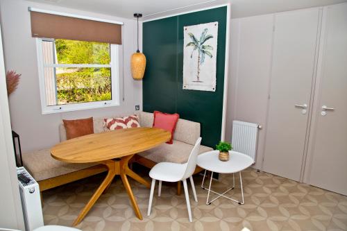 un soggiorno con tavolo e sedie in legno di Chalet Fuusslee a Goebelsmuhle