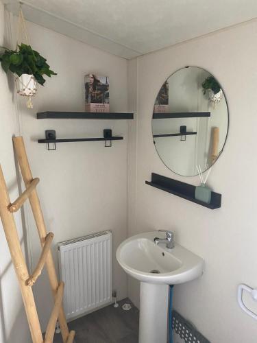 a bathroom with a sink and a mirror at Zee&Zout, chalet 6 pers. bij Renesse en strand! in Renesse