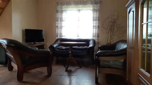 a living room with two leather chairs and a television at Domek letniskowy nad Jez. Dadaj in Biskupiec