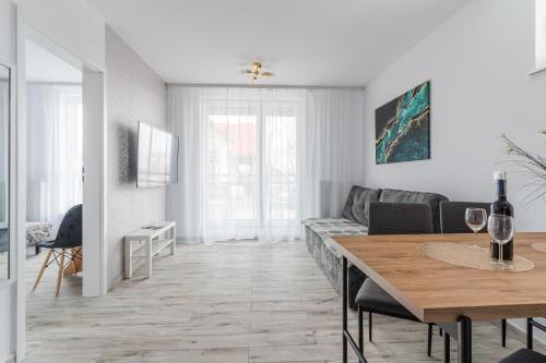a living room with a table and a couch at BURSZTYNOVA Apartamenty Piamola in Kąty Rybackie
