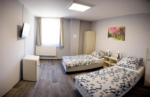 mały pokój z 2 łóżkami i oknem w obiekcie Kisgáti Vendégház w mieście Kaposvár