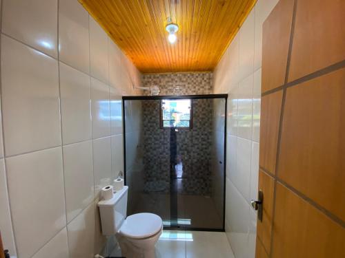 uma casa de banho com um WC e um chuveiro. em Casa Girassol em Conceição do Ibitipoca