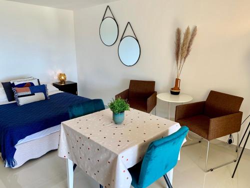 a bedroom with a table and chairs and a bed at Villa Grand Baie in Agay - Saint Raphael