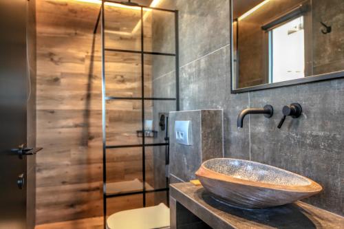 ein Badezimmer mit einem hölzernen Waschbecken und einer Dusche in der Unterkunft Meteora Heaven and Earth premium suites - Adults Friendly in Kalambaka