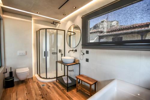 a bathroom with a sink and a toilet and a mirror at Meteora Heaven and Earth premium suites - Adults Friendly in Kalabaka