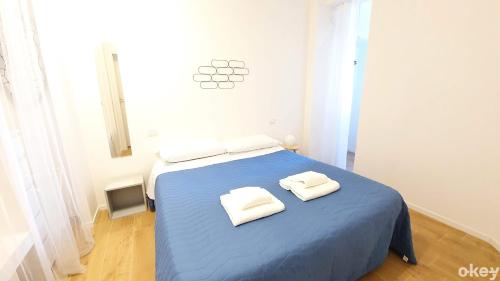 sypialnia z niebieskim łóżkiem i 2 ręcznikami w obiekcie Bed & Relax Loft - Bari Centro w mieście Bari