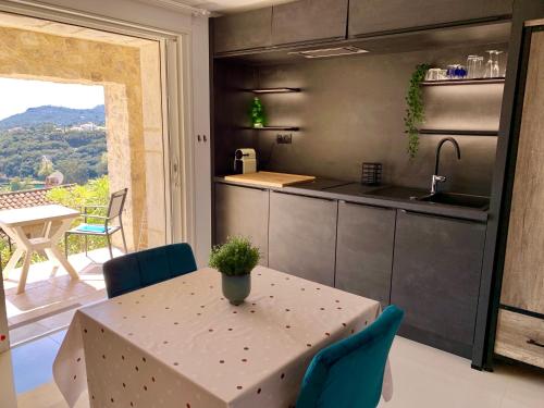 cocina y comedor con mesa y ventana en Villa Grand Baie en Agay - Saint Raphael