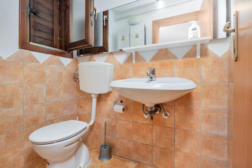 a bathroom with a toilet and a sink at San Teodoro Holiday House A in San Teodoro