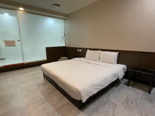 a bedroom with a large bed with white sheets and pillows at 苓旅萬年-LIN INN Wan Nian in Taipei