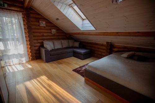 a attic room with a bed and a couch at Okka Holiday Home in Alajõe