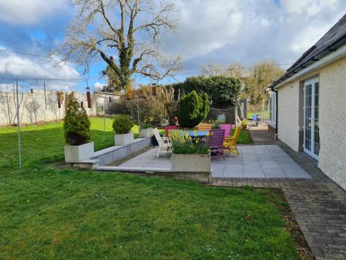 a patio with chairs and tables in a yard at Charming 1-Bed Apartment in Barefield in Ennis
