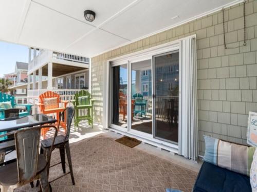 a room with a balcony with a table and chairs at Laid Back By The Sea - Steps from the beach with amazing ocean views, Parking for 2 included, condo in Carolina Beach