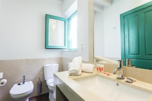 a bathroom with a sink and a toilet and a mirror at Apartamentos Laurel Suites in Granada