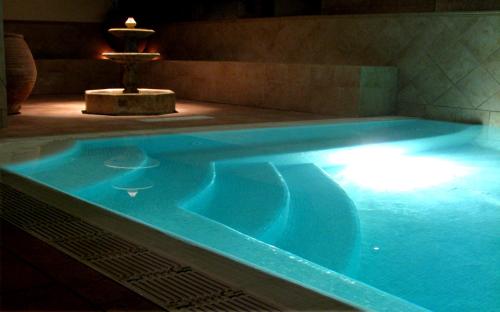 a large swimming pool in a room with a fountain at Apartamentos Laurel Suites in Granada