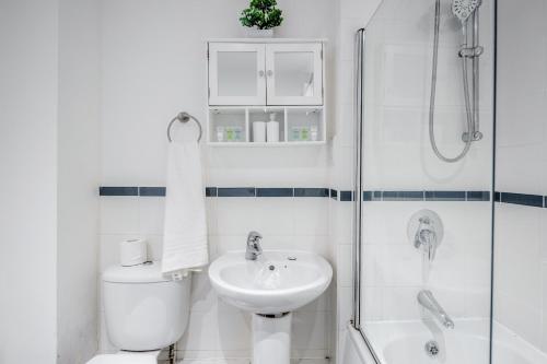 y baño con lavabo, aseo y ducha. en Bright and cozy 2-Bed Apartment in Dagenham, en Dagenham