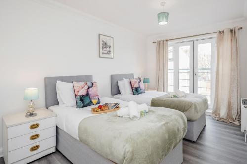 達格納姆的住宿－Bright and cozy 2-Bed Apartment in Dagenham，一间带两张床和一张沙发的卧室