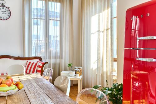 a dining room with a table and a red refrigerator at Al Cavour 34 in Trento