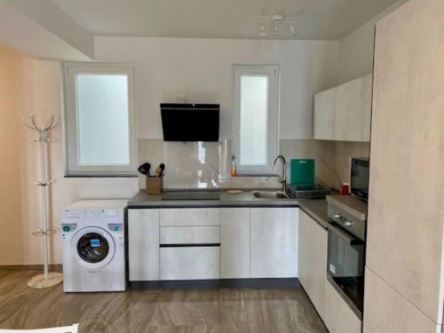 a kitchen with a washing machine and a washer at Sliema, Stylish 1 Bedroom Apartment with Parking. in Sliema